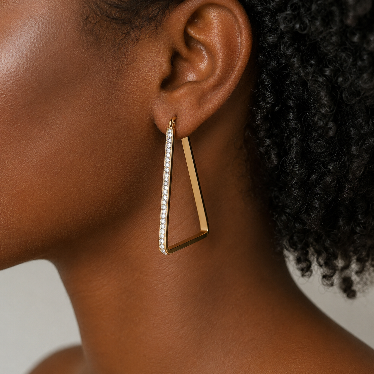 Gold triangle cubic zirconia earrings, close-up by Trendzio Jewelry
