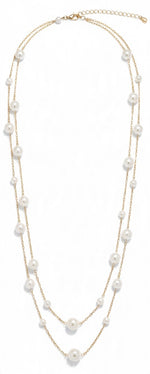 Double row glass pearl necklace in gold with white pearls in mixed sizes on two fine chains