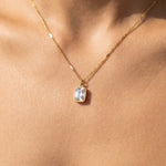 Gold rectangle CZ bezel pendant necklace worn at the collarbone