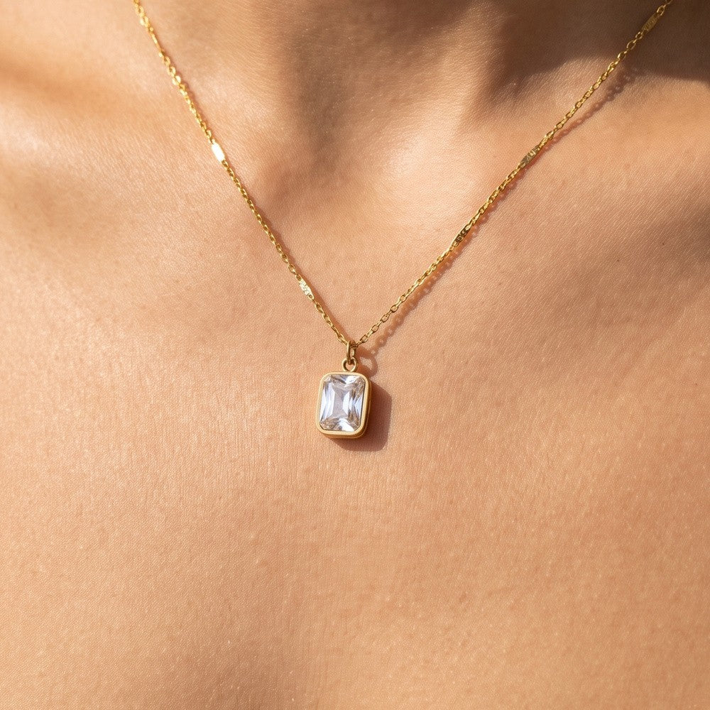 Gold rectangle CZ bezel pendant necklace worn at the collarbone