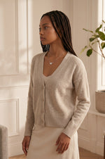 Model wearing a Trendzio Jewelry sterling silver ivy leaf necklace with CZ accents, styled with a beige cardigan.