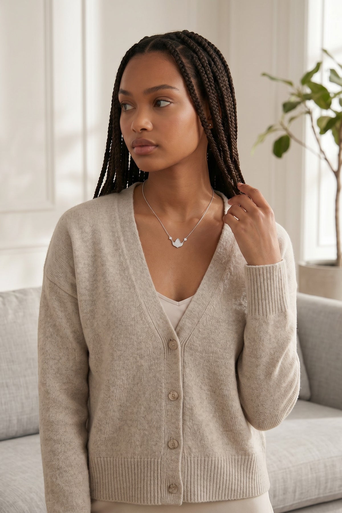 Model wearing a Trendzio Jewelry sterling silver AKA ivy leaf necklace with CZ stones and a beige cardigan.
