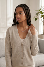 Model wearing a Trendzio Jewelry sterling silver AKA ivy leaf necklace with CZ stones and a beige cardigan.