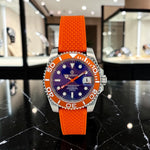 Trendzio Jewelry Blue Amber Mariner automatic watch with orange rubber strap, blue dial, and orange bezel. Features a date window.