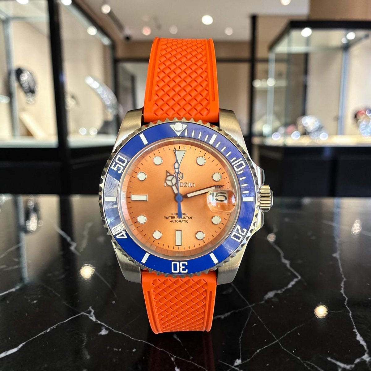 Trendzio Jewelry Blue Amber automatic watch with orange dial, blue bezel, and orange rubber strap. Inspired by Submariner design.