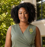 Trendzio Jewelry yellow and green crystal rose lapel pin worn by a woman in an olive green dress