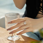 Trendzio Jewelry sterling silver clover ring with sparkling CZ diamonds worn by a woman holding a glass