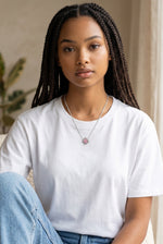Model wearing a Trendzio Jewelry sterling silver clover necklace with pink and green CZ stones on a white t-shirt.