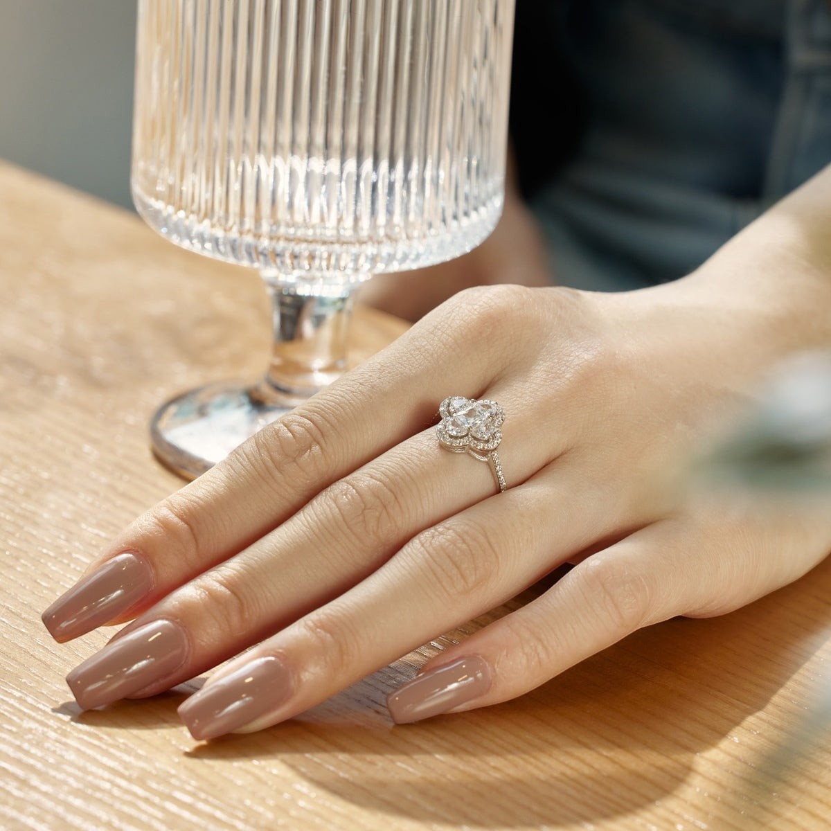 Trendzio Jewelry sterling silver clover CZ diamond ring worn on a woman's hand with nude manicure