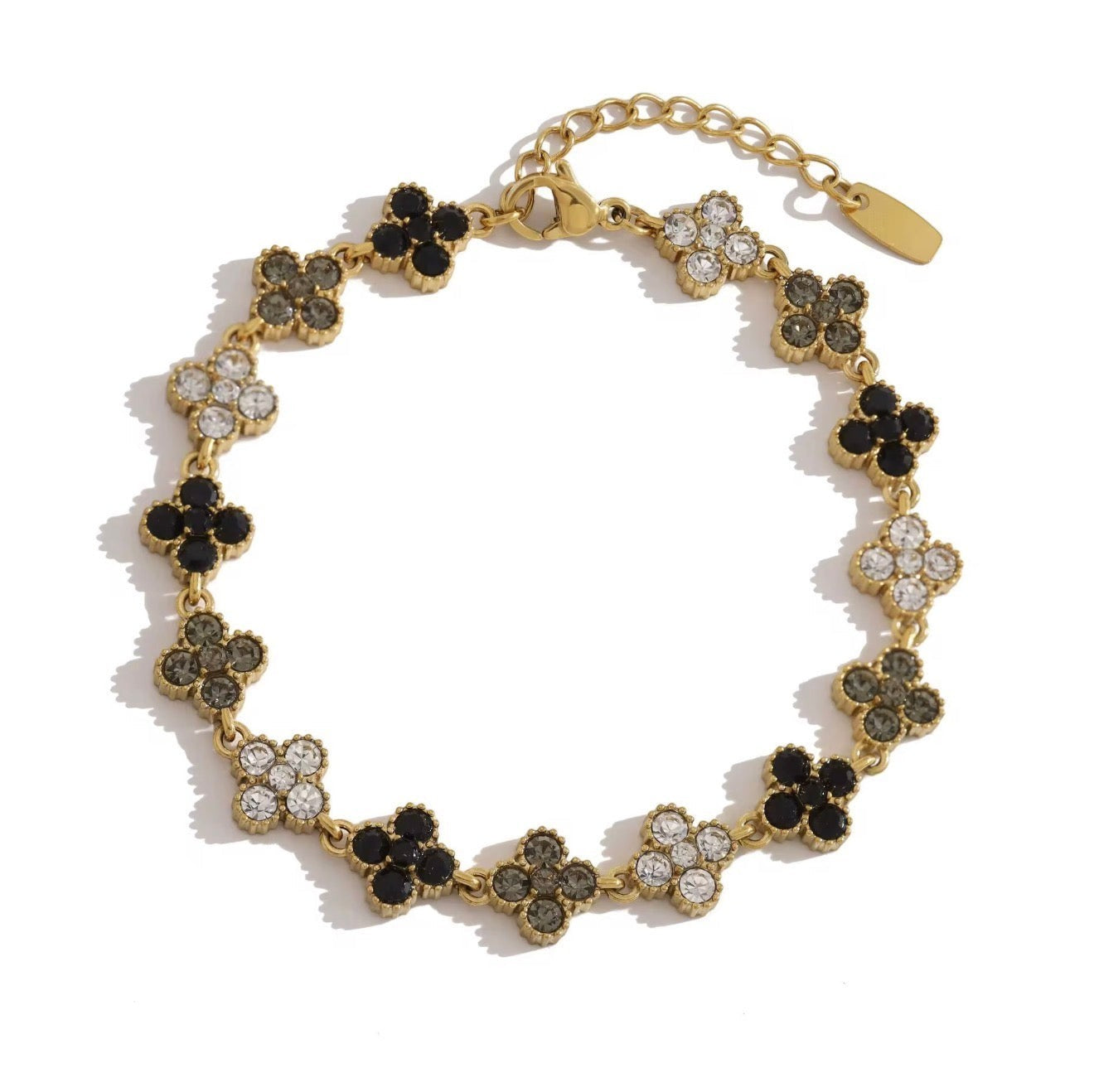 Trendzio Jewelry gold-plated stainless steel clover bracelet featuring black and clear CZ stones on a white background.