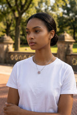 Model wearing a Trendzio Jewelry sterling silver Kaitlin clover necklace with pink and green CZ stones outdoors.