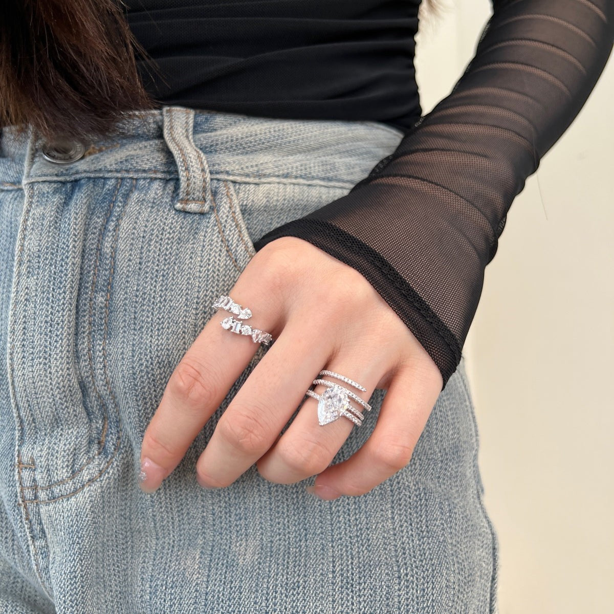 Trendzio Jewelry Lolo sterling silver CZ ring with pear-cut stone worn on a hand with casual denim and mesh top.