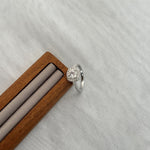Trendzio Jewelry sterling silver Mira moissanite ring with a halo setting on a wooden display stand