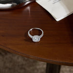 Trendzio Jewelry Mira moissanite ring in sterling silver with a sparkling halo setting on a wooden table