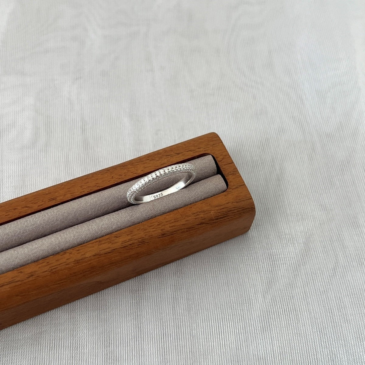 Trendzio Jewelry Nola sterling silver moissanite band ring with pavé stones in a wooden display box