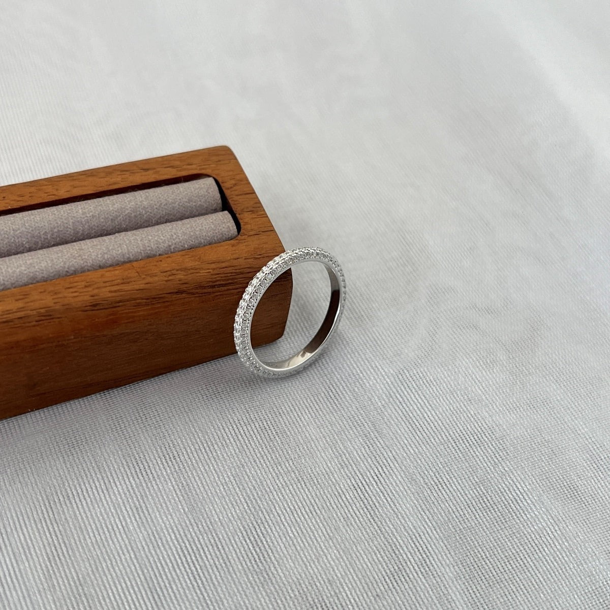 Trendzio Jewelry Nola sterling silver moissanite eternity band ring with sparkling pavé stones in a wooden box.