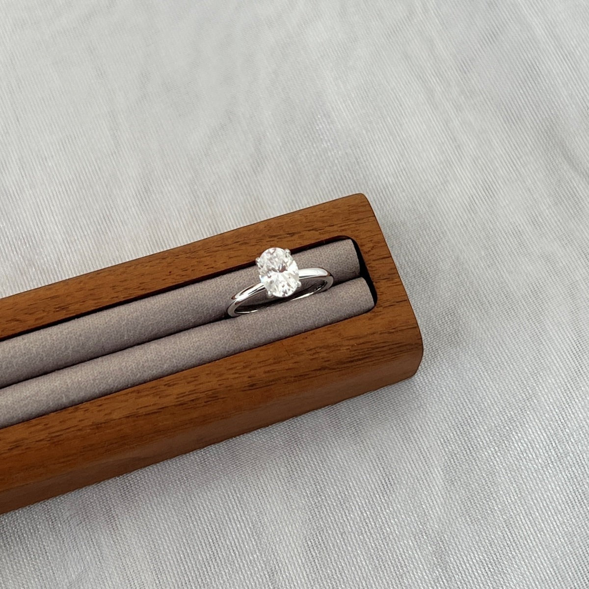 Trendzio Jewelry Sloane oval moissanite ring in sterling silver, displayed in a wooden ring box.