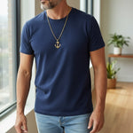 Trendzio Jewelry gold stainless steel anchor pendant necklace on a man wearing a navy t-shirt.