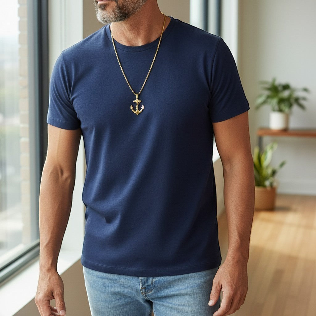 Trendzio Jewelry gold stainless steel anchor pendant necklace on a man wearing a navy t-shirt.