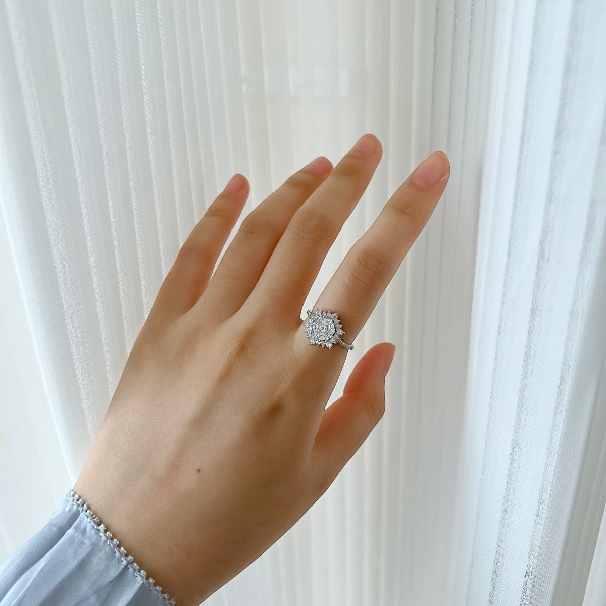 Trendzio Jewelry Veda sterling silver ring with a sparkling hexagonal CZ diamond cluster on a woman's finger.